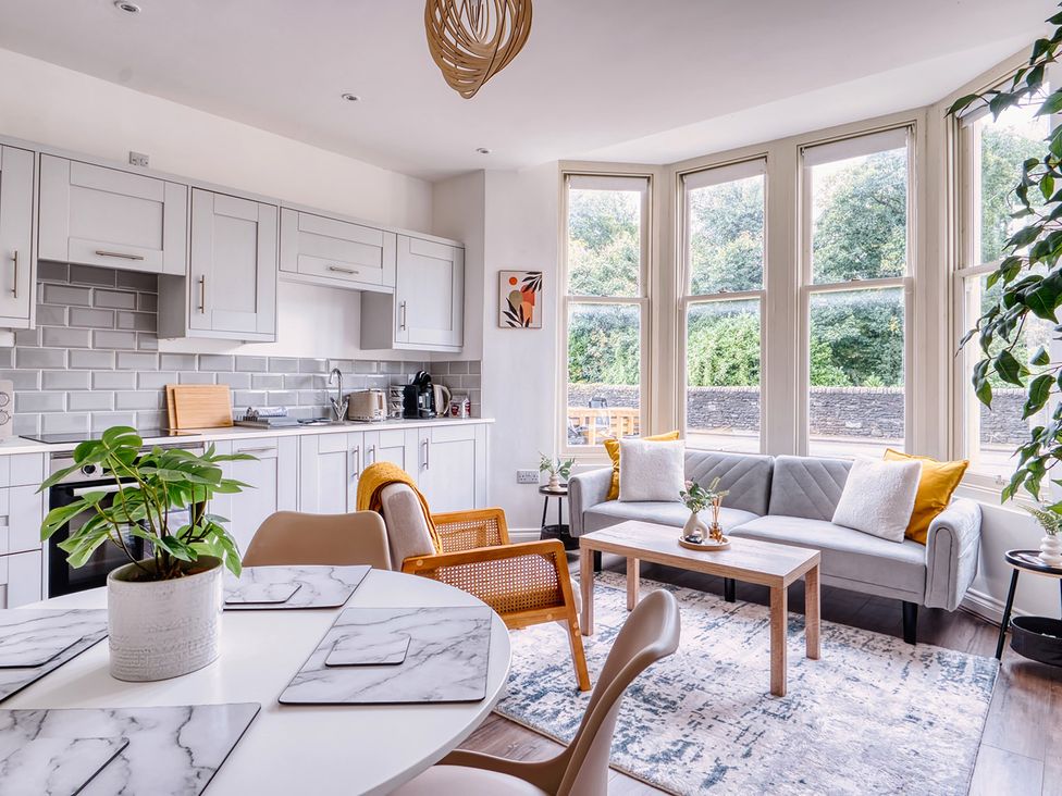 A kitchen and living area with dining table and sofa at Stunning 2 Bed by the City Centre and Bute Park, Cardiff