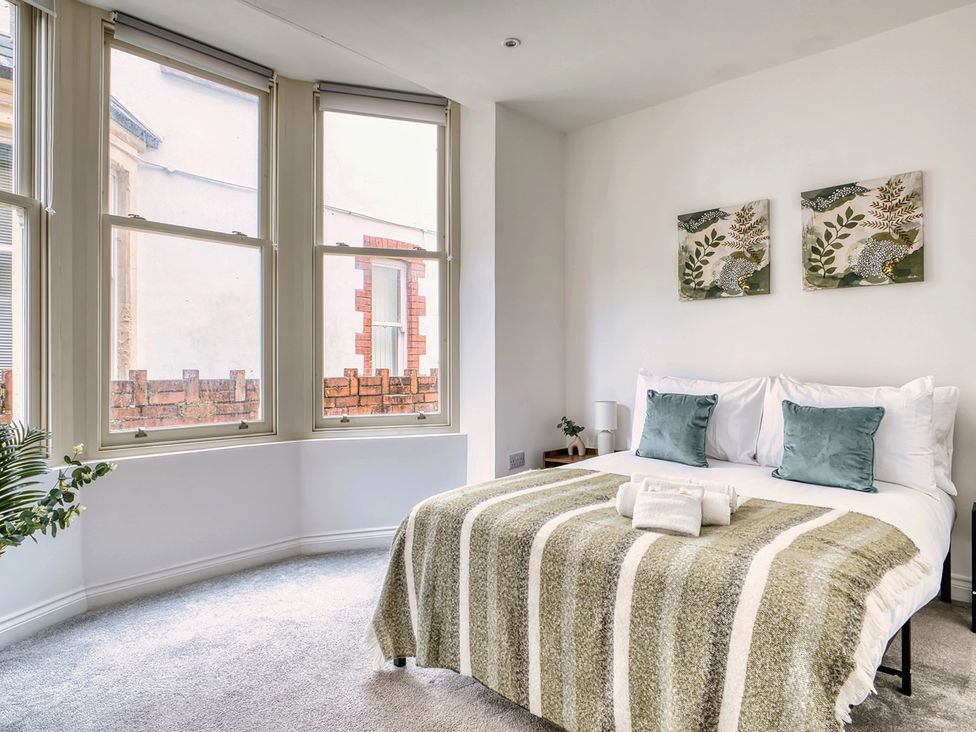A bedroom with a bed and windows at Stunning 2 Bed by the City Centre and Bute Park Cardiff