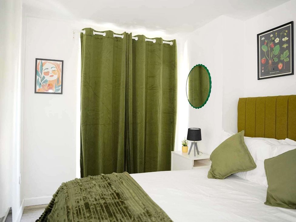 A bedroom with a bed and bedside table at Ground Floor Apartment Sleeps 4 with Parking Cardiff