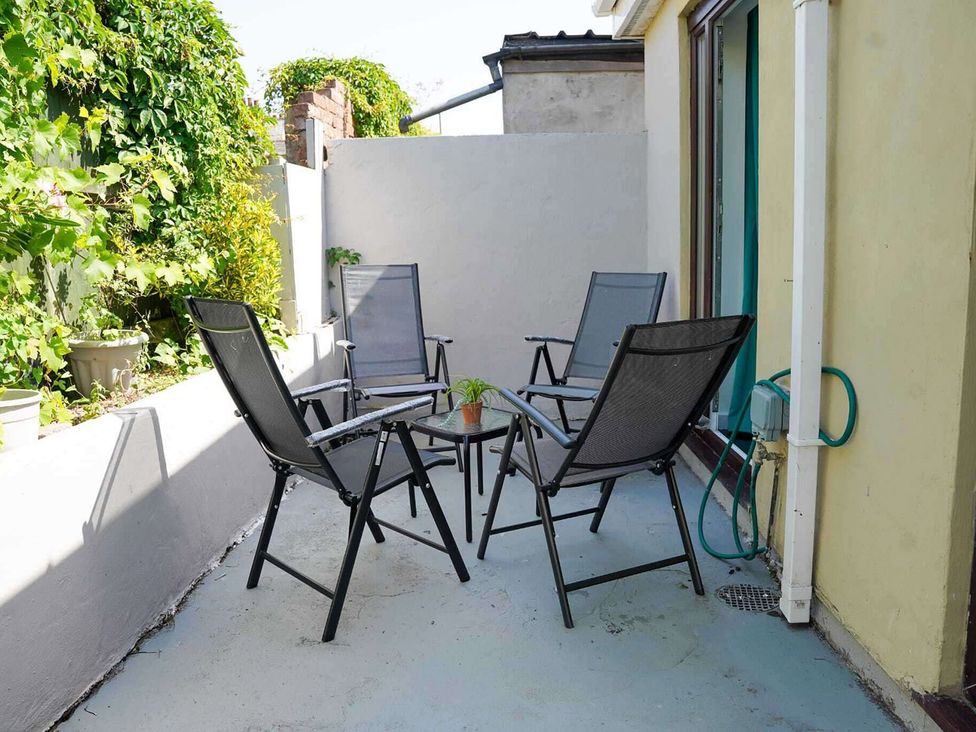 A patio with seating and a table at Ground Floor Apartment Sleeps 4 with Parking Cardiff