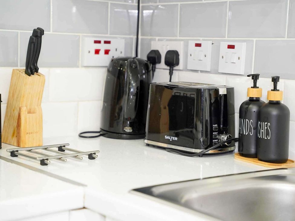 Kitchen countertop with appliances and utensils at Ground Floor Apartment Sleeps 4 with Parking in Cardiff