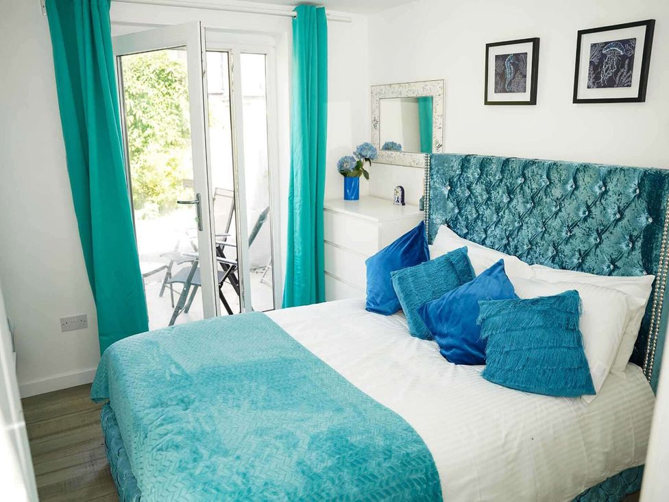 A bedroom with a bed and sliding door at Ground Floor Apartment Sleeps 4 with Parking in Cardiff