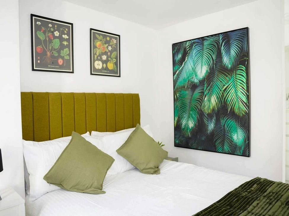 A bedroom with a bed and framed artwork at Ground Floor Apartment Sleeps 4 with Parking in Cardiff
