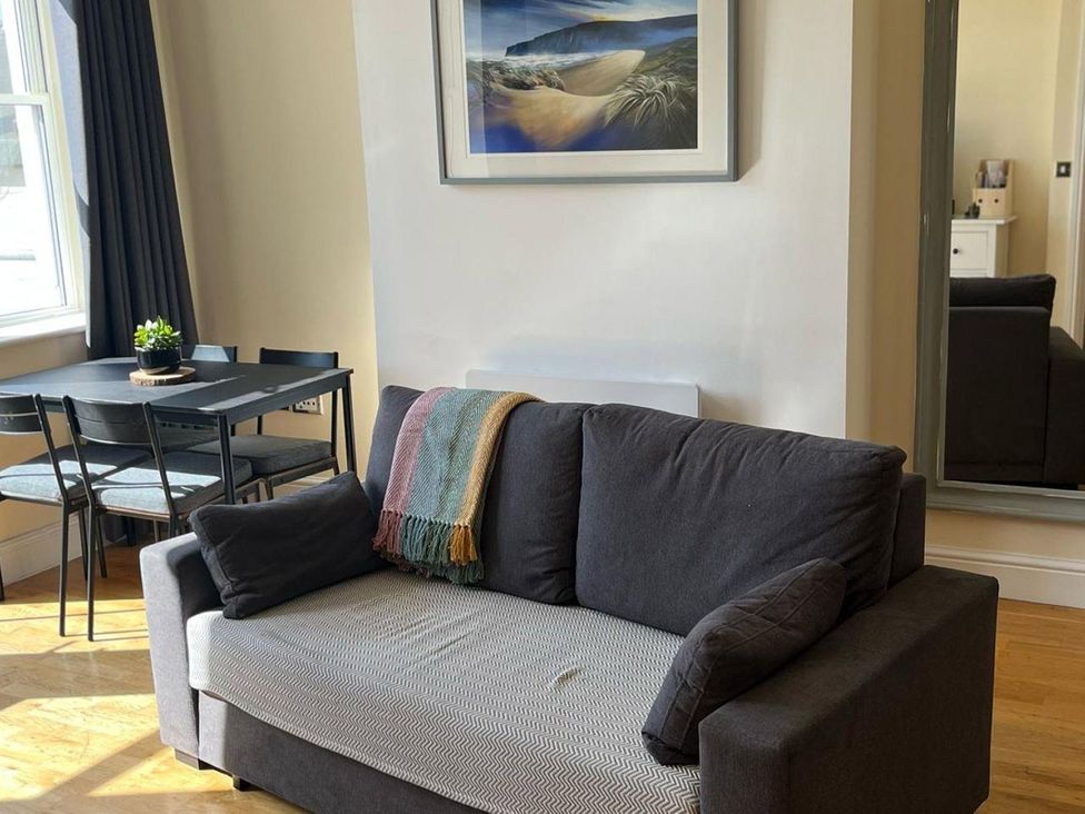 A living room with a sofa and dining area at Cardiff Apartment, sleeps 6, Castle and Stadium nearby, Cardiff