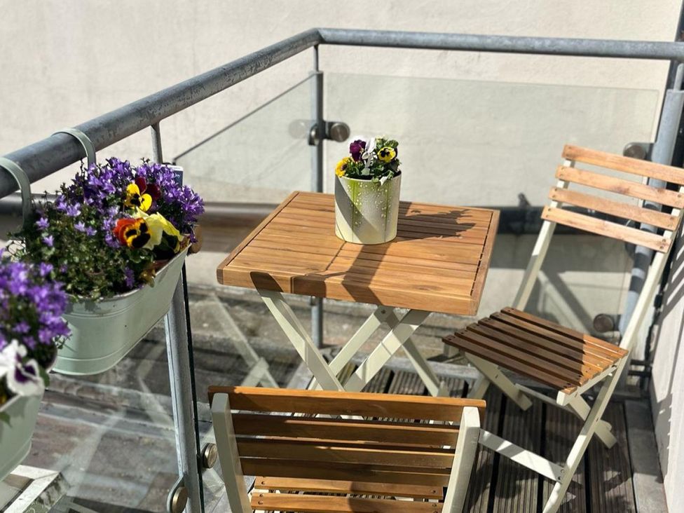 A patio with a table and chairs and potted flowers at Cardiff Apartment, sleeps 6, Castle and Stadium nearby Cardiff