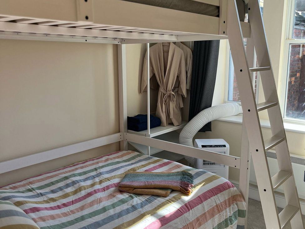A bedroom with a bunk bed, air conditioner, and a shelf at Cardiff Apartment, sleeps 6, Castle and Stadium nearby, Cardiff