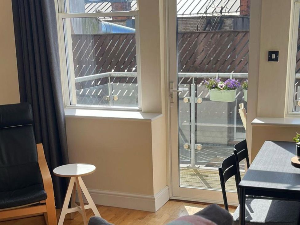 A living room with a window and door leading to a balcony at Cardiff Apartment, sleeps 6, Castle and Stadium nearby, Cardiff