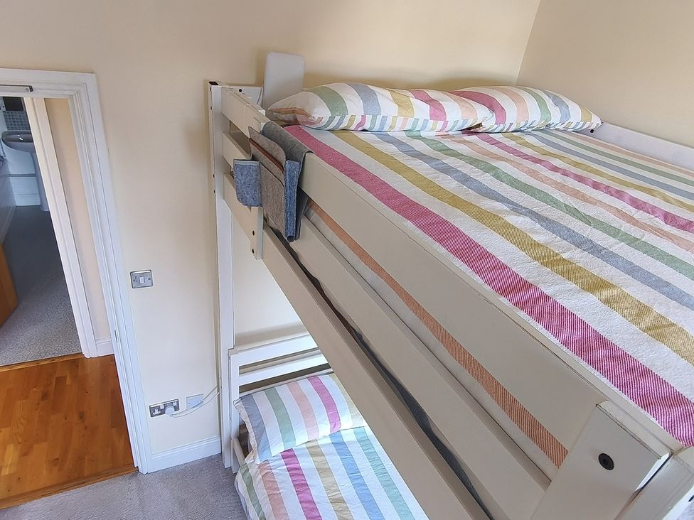 A bunk bed with striped bedding in Cardiff Apartment, sleeps 6, Castle and Stadium nearby, Cardiff