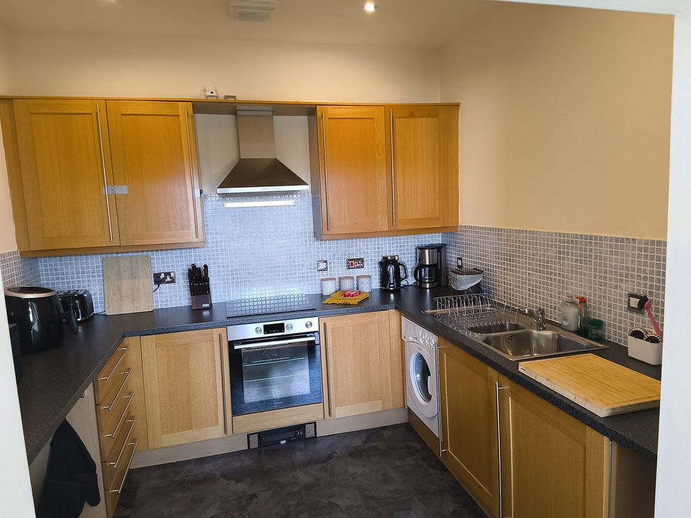 A kitchen with cabinets, stove, sink, and appliances at Cardiff Apartment, sleeps 6, Castle and Stadium nearby, Cardiff