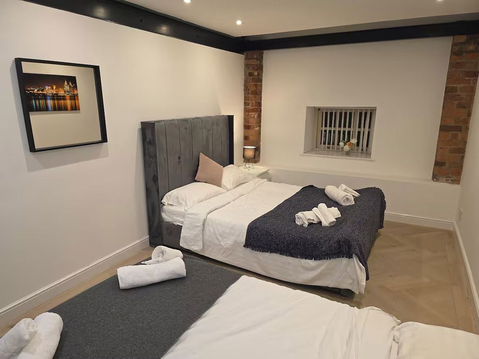 A bedroom with two beds and a window at Liverpool Penthouse, sleeps 8 Liverpool