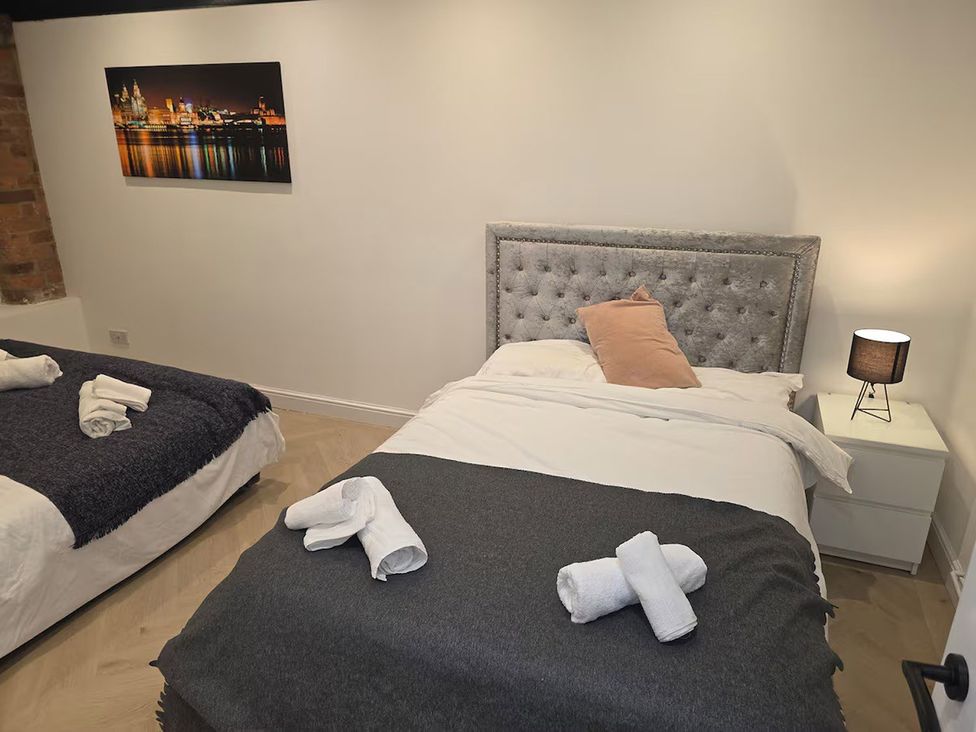 A bedroom with two beds and a nightstand at Liverpool Penthouse, sleeps 8 Liverpool