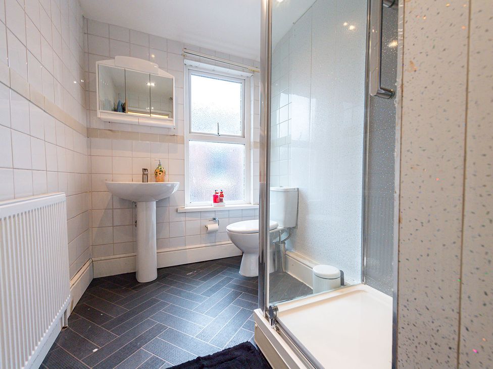 A bathroom featuring a sink, mirror, shower, and toilet at 5 Bed House, sleeping 10 in the City Centre, Liverpool