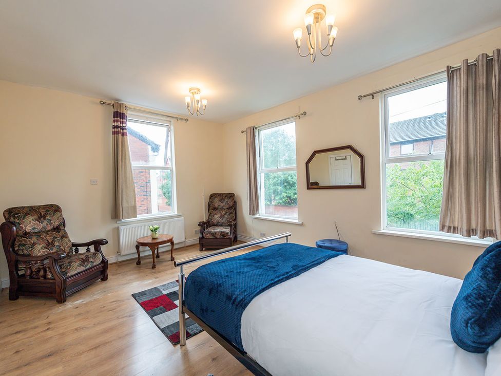 A bedroom with a bed and two armchairs at 5 Bed House, sleeping 10 in the City Centre Liverpool
