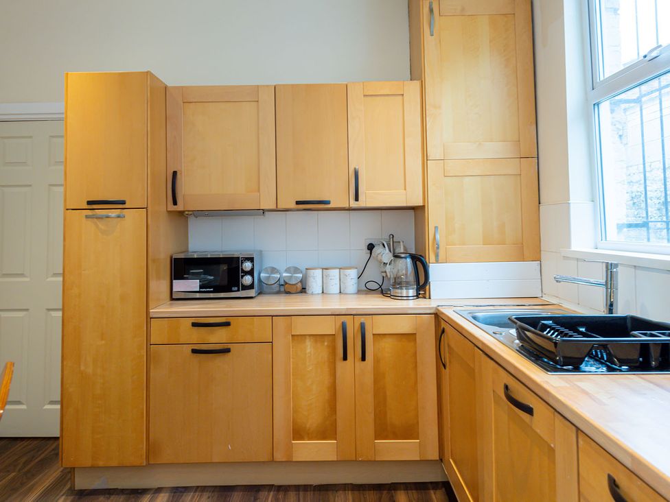 A kitchen with cabinets, a microwave, kettle, and sink at 5 Bed House, sleeping 10 in the City Centre Liverpool