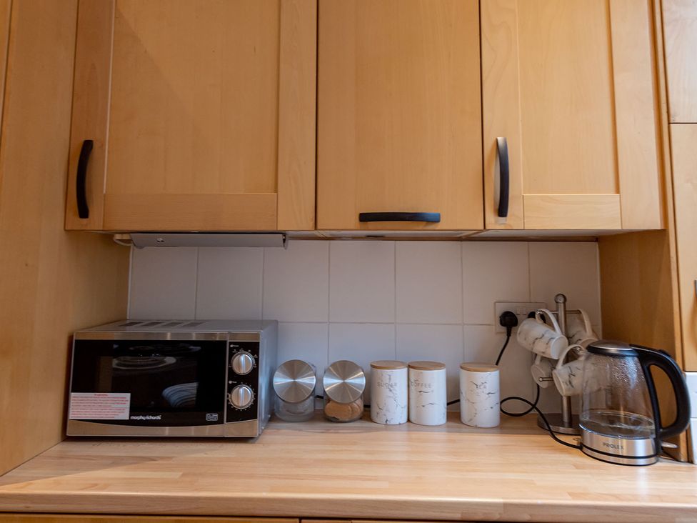 A kitchen with a microwave, kettle, and storage canisters at 5 Bed House, sleeping 10 in the City Centre, Liverpool