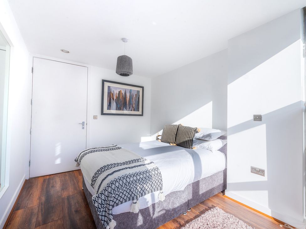 A bedroom with a bed and a painting at City Centre Apartment, 2 bed with Free Parking Liverpool