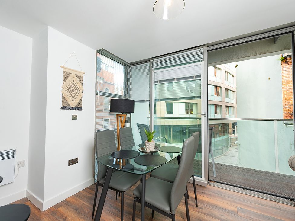 A dining room with a table and chairs near a window at City Centre Apartment, 2 bed with Free Parking Liverpool