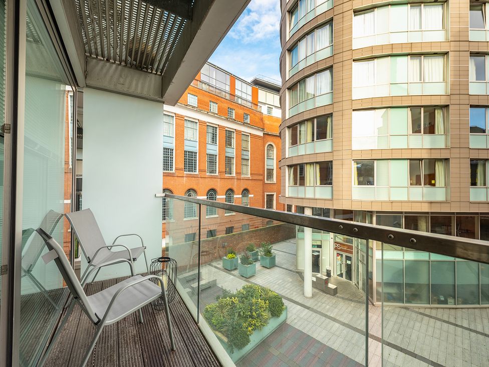 A balcony with chairs overlooking a courtyard at City Centre Apartment, 2 bed with Free Parking, Liverpool