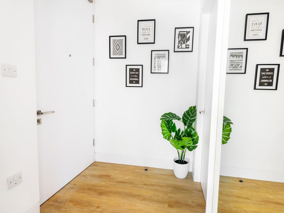 An entrance hall with wall art and a plant at Luxury City Centre Apartment, Prime Location Liverpool