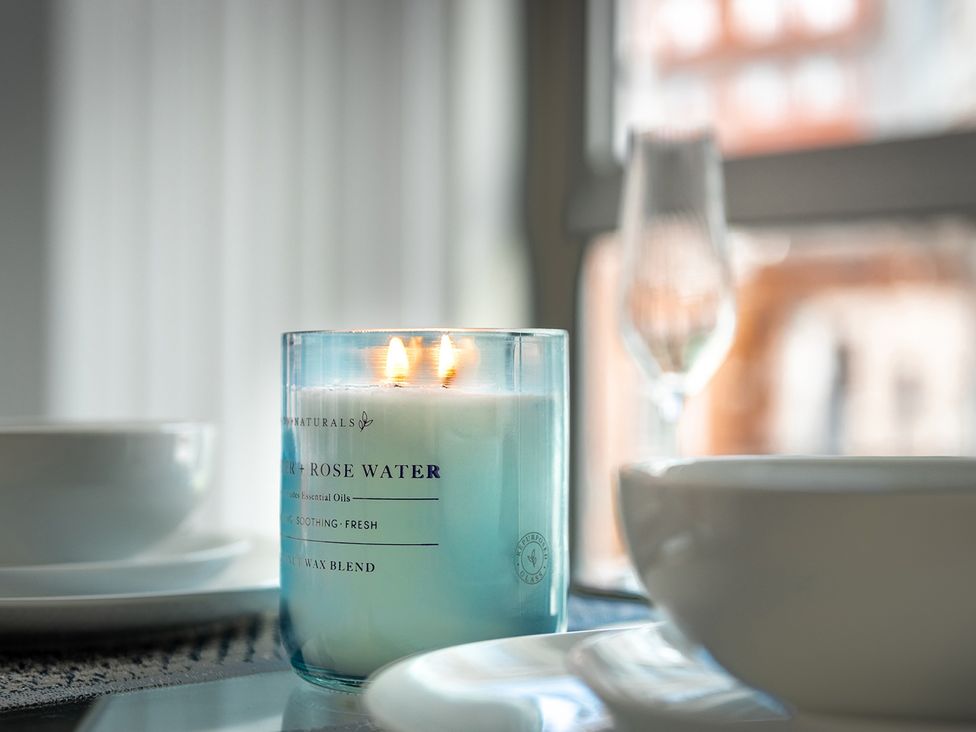 A candle and a glass beside a bowl on a table at Luxury City Centre Apartment, Prime Location Liverpool
