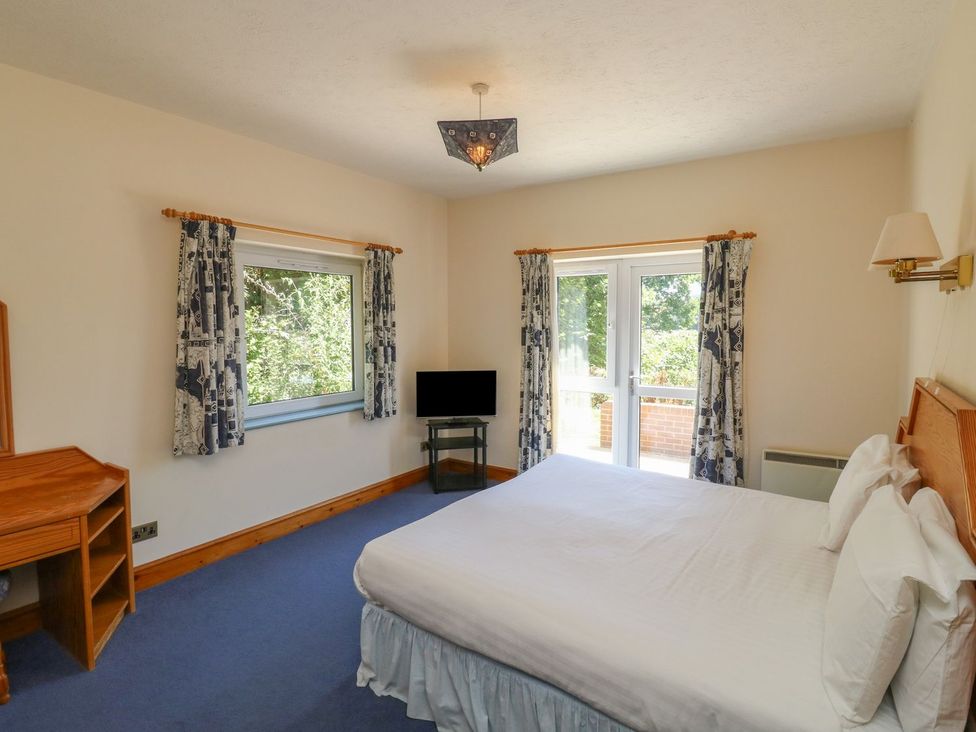 A bedroom with a bed and television at Willow in Kingsteignton