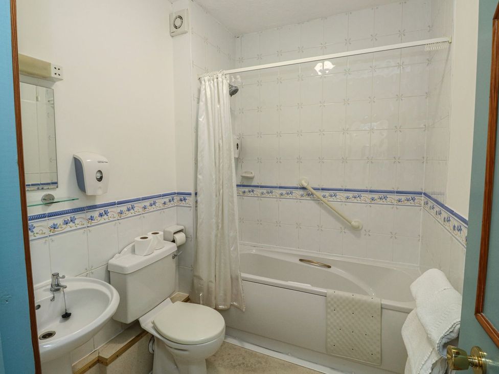 A bathroom with a bathtub, toilet, and sink at Willow in Kingsteignton