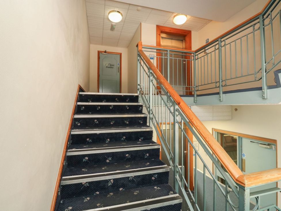 A stairwell with a staircase and a door at Goldfinch in Kingsteignton