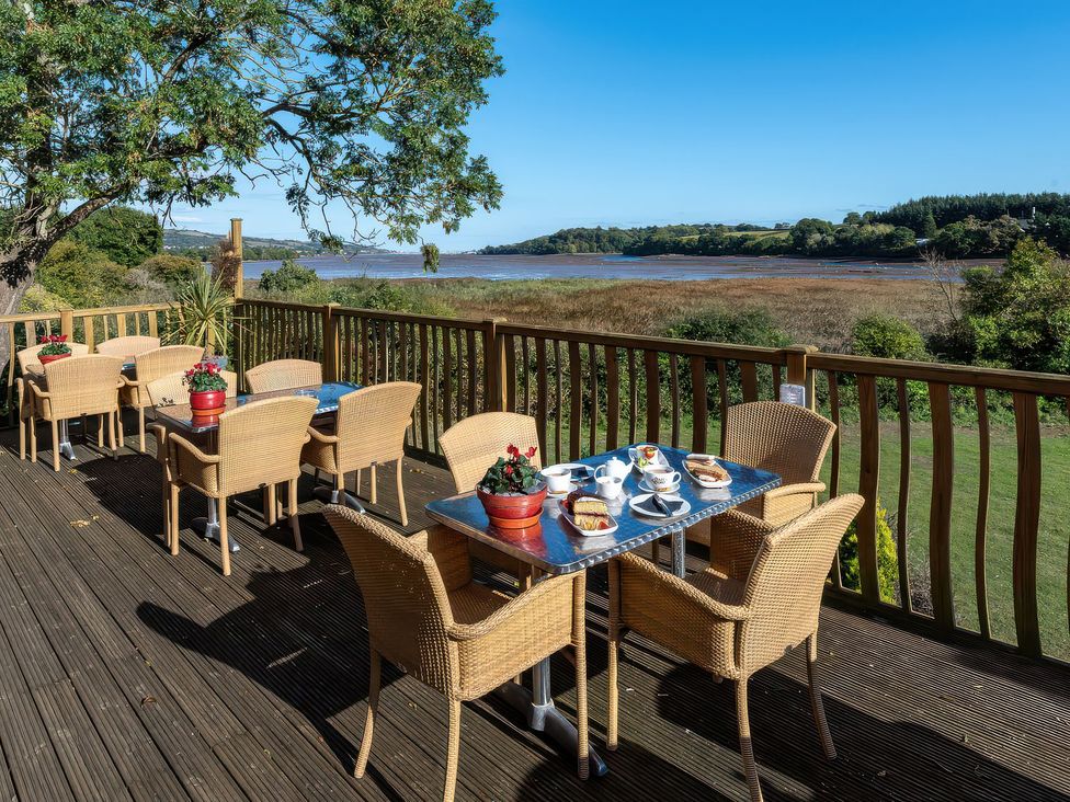An outdoor dining area with tables and chairs at Oakwood in Kingsteignton