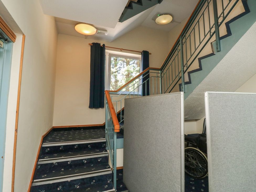 A staircase with a wheelchair and curtains at Moorhen in Kingsteignton