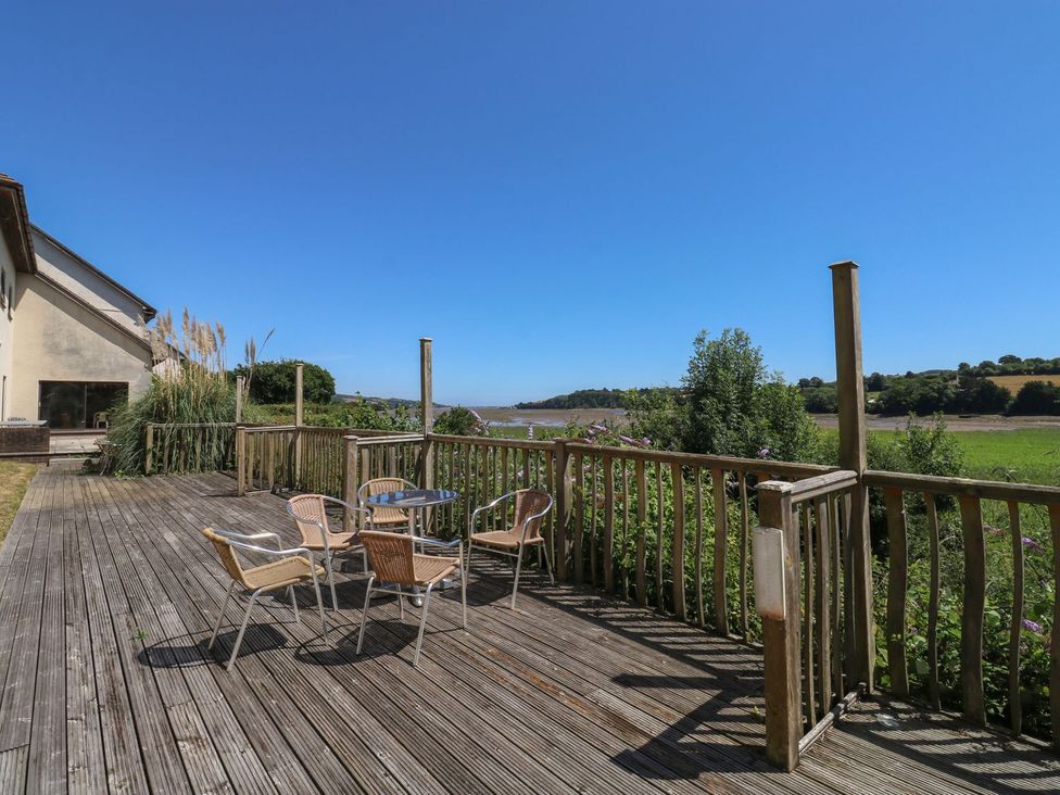 A deck area with chairs and a table at Moorhen in Kingsteignton