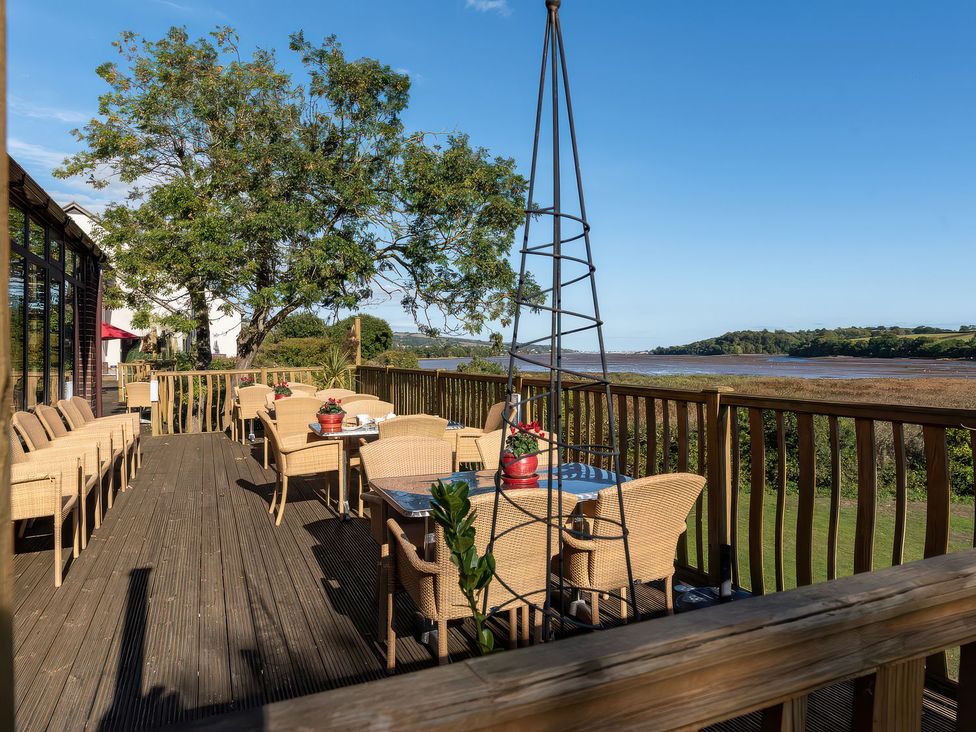An outdoor deck area with tables and chairs at Moorhen in Kingsteignton