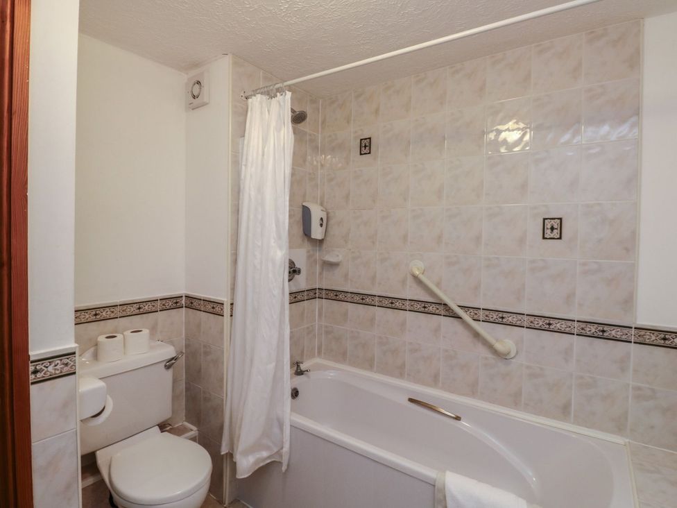 A bathroom with a bathtub and toilet at Moorhen in Kingsteignton