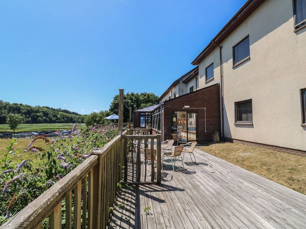 A garden area with a deck and chairs at Moorhen in Kingsteignton