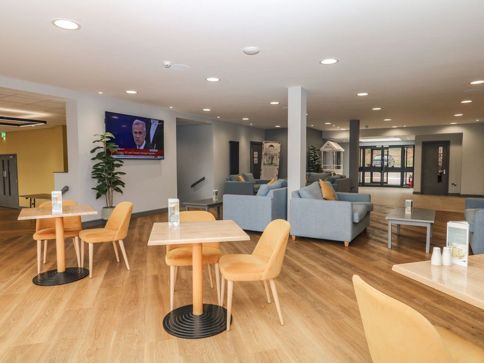 A lounge area with seating and a television at Guillemot in Kingsteignton