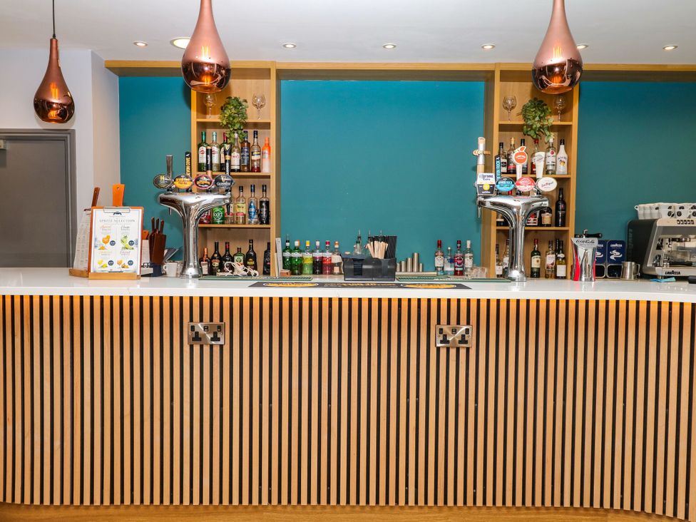 A bar counter with drinks and a coffee machine at Guillemot in Kingsteignton