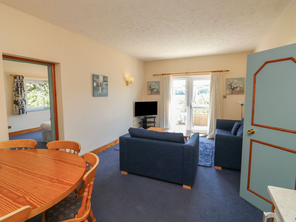 A living room with a sofa and dining table at Egret in Kingsteignton