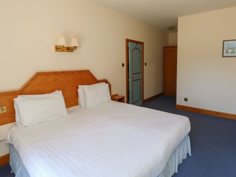 A bedroom with a bed and wardrobe at Egret in Kingsteignton