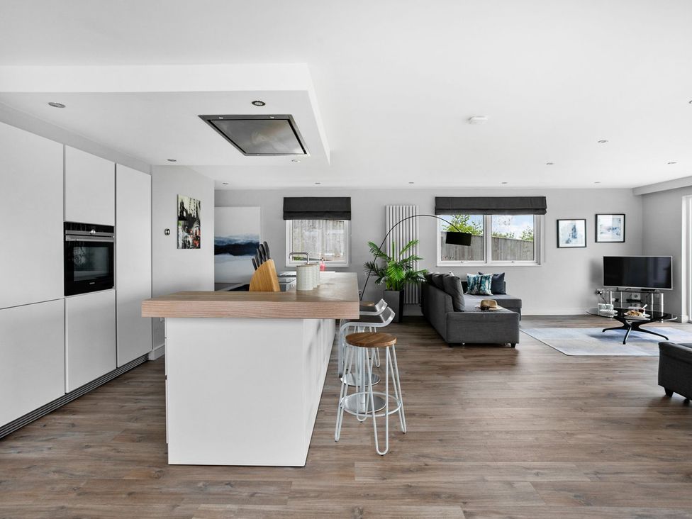 A kitchen with a living area featuring a sofa and television at Huxham View & Annex in Kingsteignton