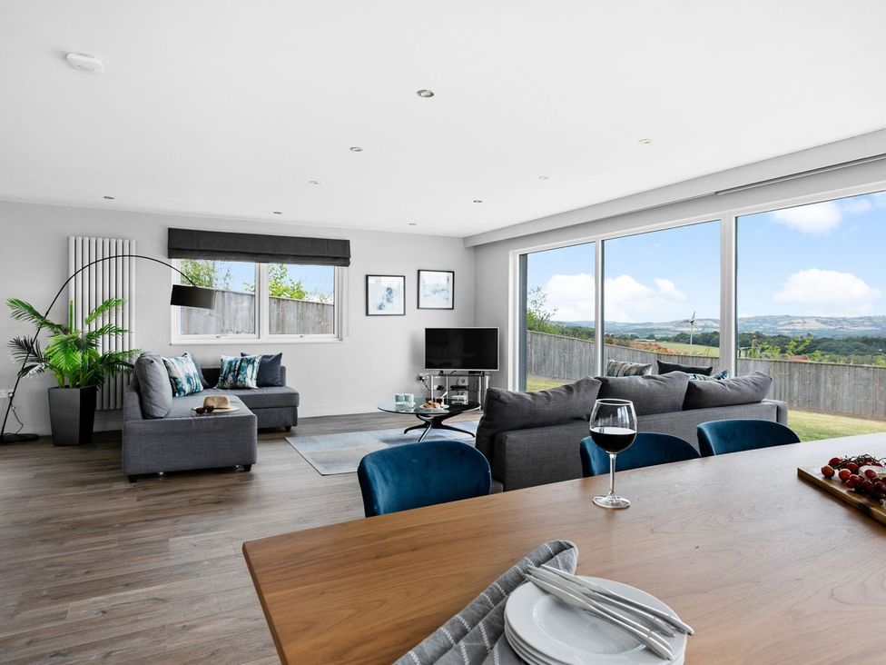 A living room with a sofa and television at Huxham View & Annex in Kingsteignton
