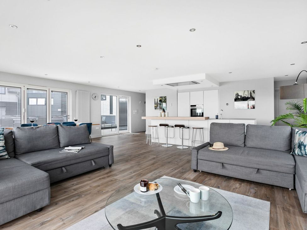 A living room with sofas and a kitchen island at Huxham View & Annex in Kingsteignton
