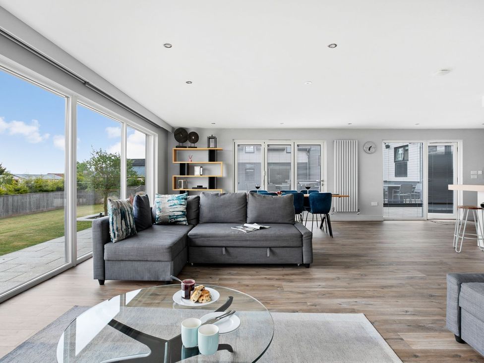 A living room with a sofa and glass table at Huxham View & Annex in Kingsteignton