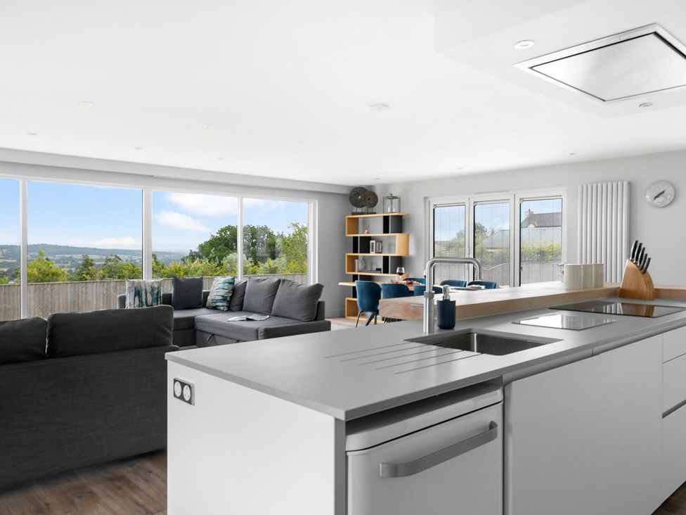A living room with a sofa and kitchen island at Huxham View & Annex in Kingsteignton