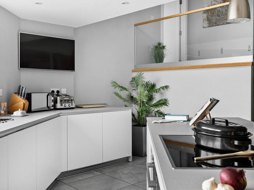 A kitchen with modern appliances and a plant at Huxham View & Annex in Kingsteignton