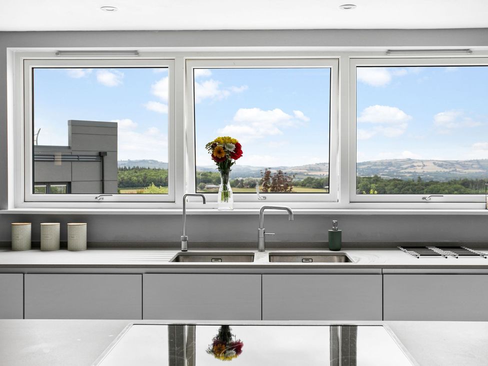 A kitchen with sink and windows showing a view at Huxham View & Annex in Kingsteignton