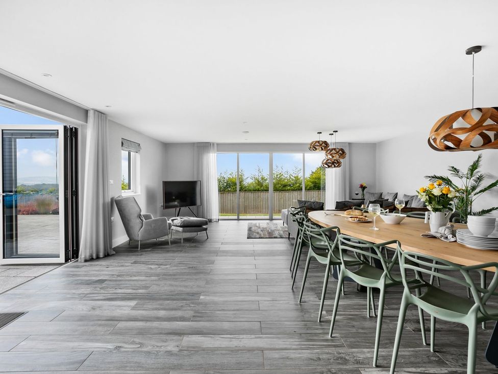 A dining room with a table and chairs at Huxham View & Annex in Kingsteignton