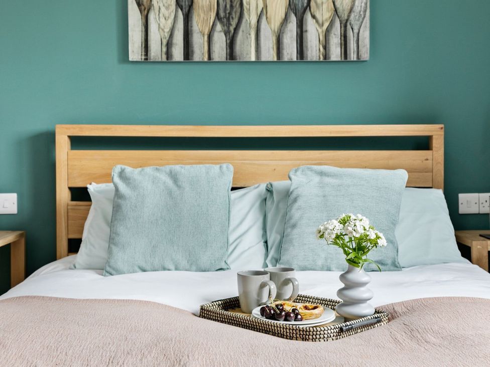 A bedroom with a bed and a tray of drinks at Huxham View & Annex in Kingsteignton