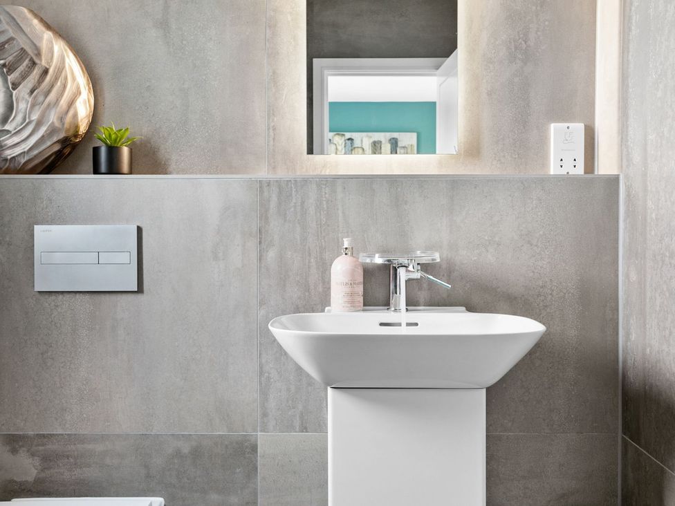 A sink with a tap and soap dispenser in a bathroom at Huxham View & Annex in Kingsteignton