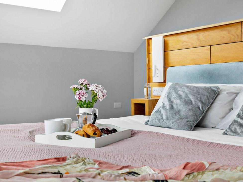A bedroom with a bed and breakfast tray at Huxham View & Annex in Kingsteignton