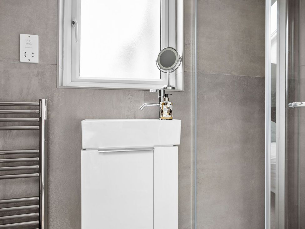 A bathroom with a sink and towel radiator at Huxham View & Annex in Kingsteignton