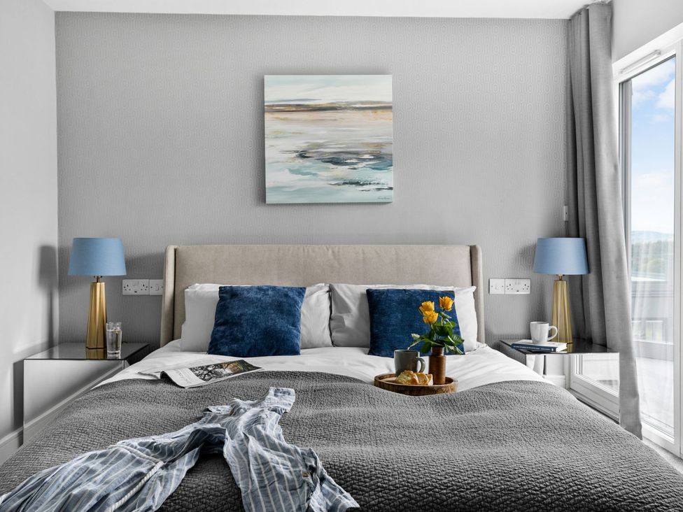 A bedroom with a bed and flowers on a tray at Huxham View & Annex in Kingsteignton